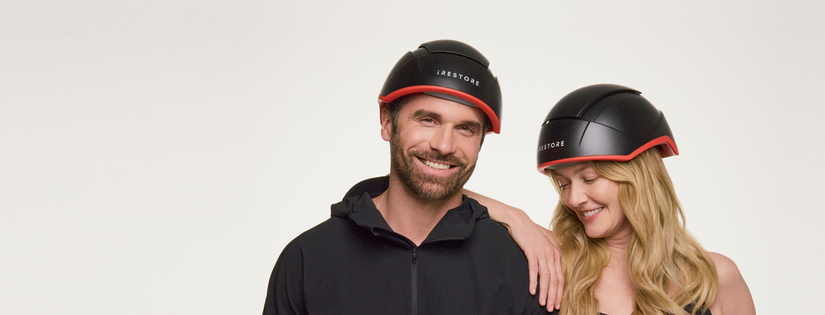 Couple wearing iRESTORE hair growth devices
