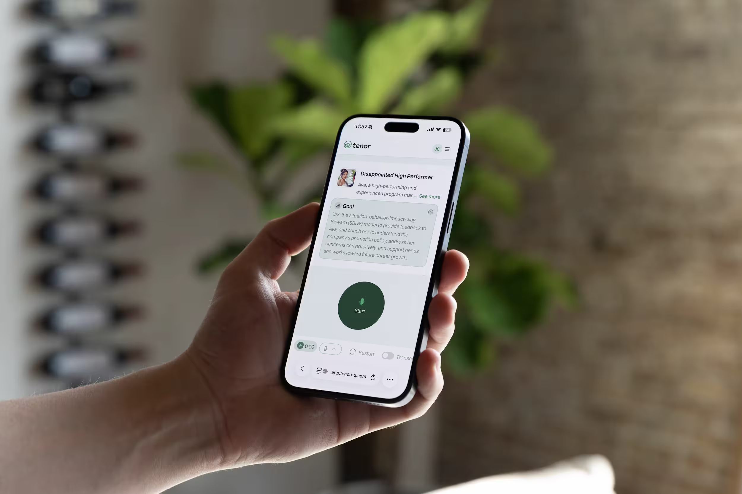 Hand holding phone showing Tenor AI coaching app