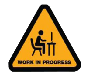 Worker seated at a desk inside a yellow work in progress warning sign