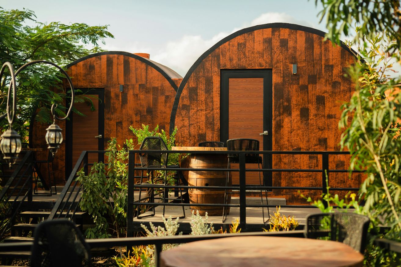 Rustic cabin suites with curved wooden facade and outdoor deck