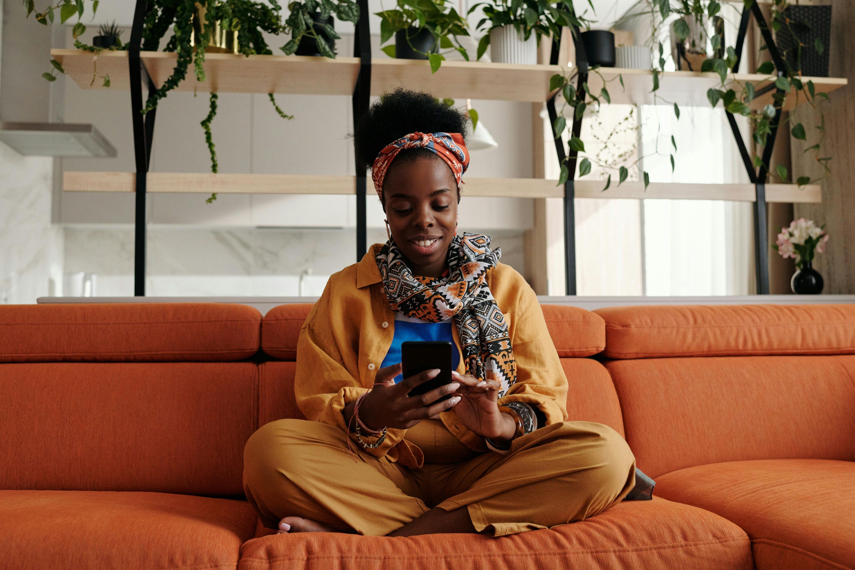 Woman at home comfortably reviewing her OB-GYN care plan on her phone