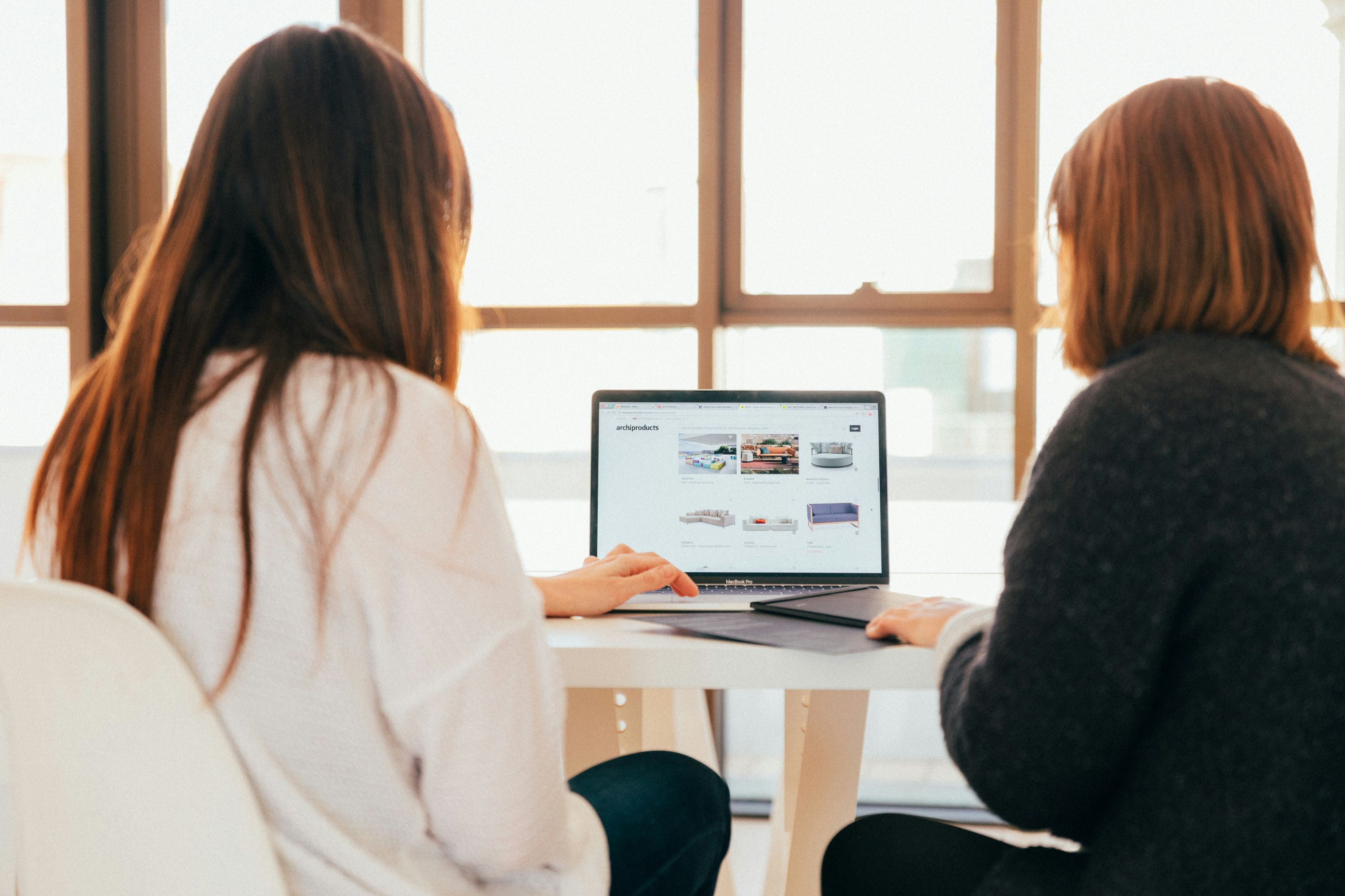 Two women reviewing analytics data on a laptop