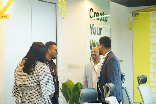 Colleagues talking in a bright modern office meeting space