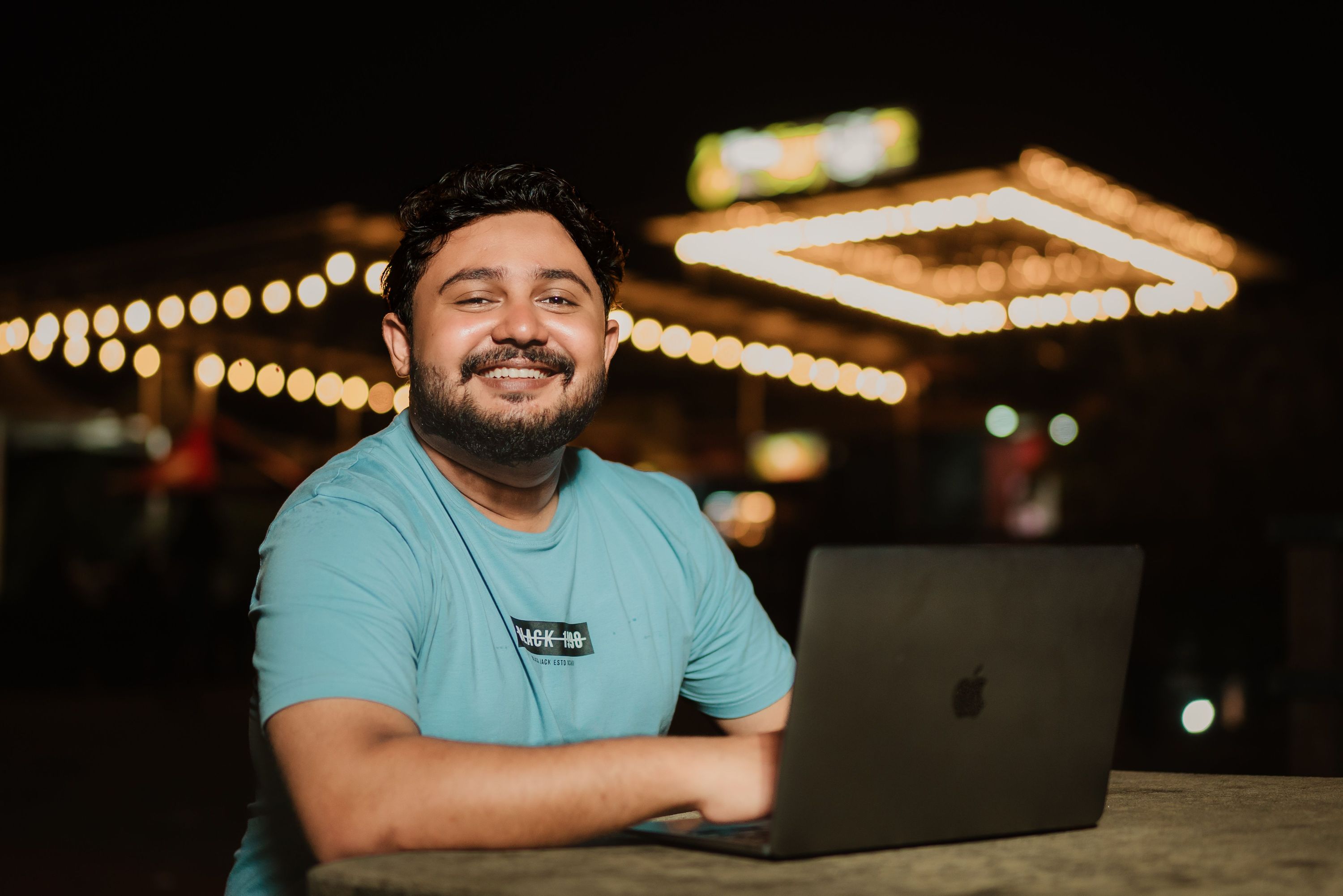 Man using a laptop at an outdoor cafe