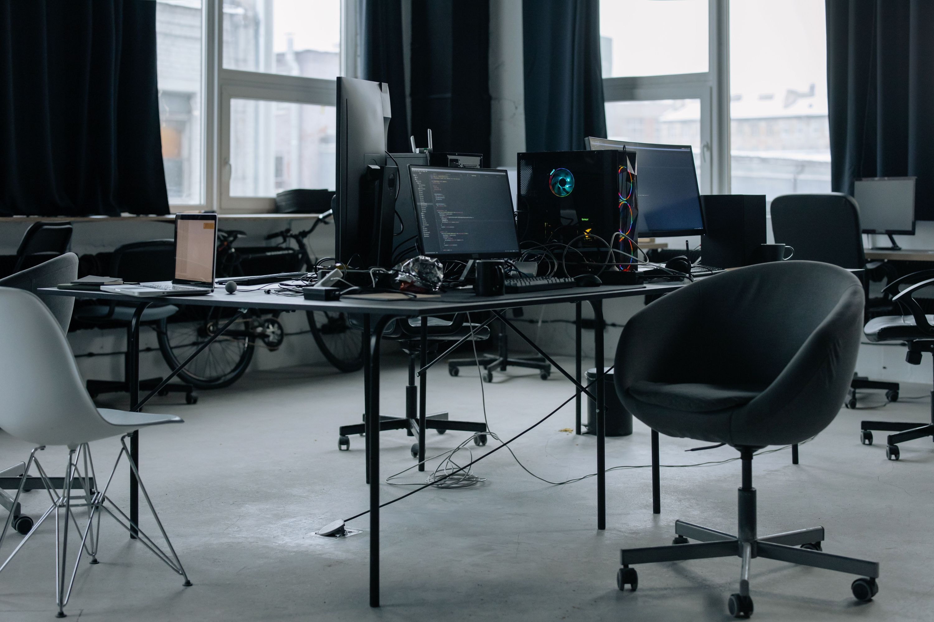 Computer monitors and laptops on desks in a modern office
