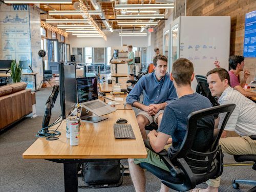 Coworkers collaborating around a desk in a bright office