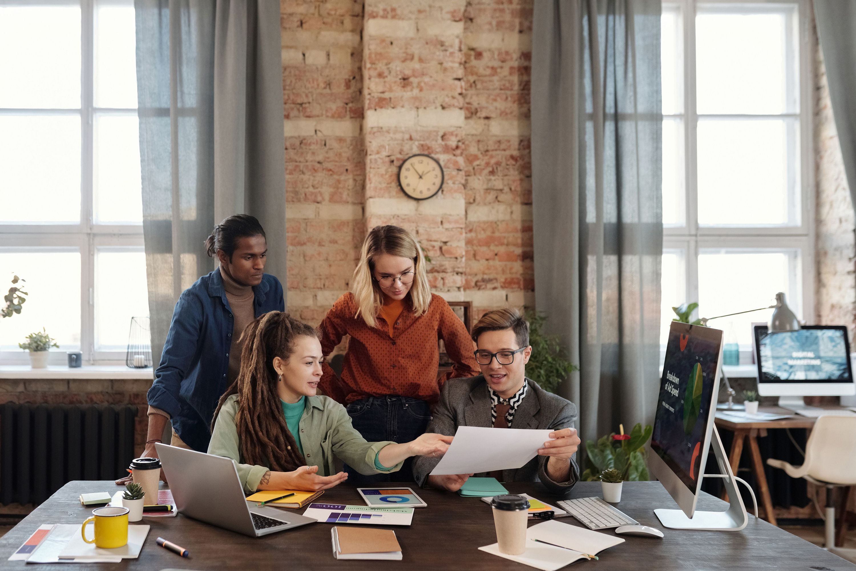 A group of coworkers collaborating around a desk in a modern office
