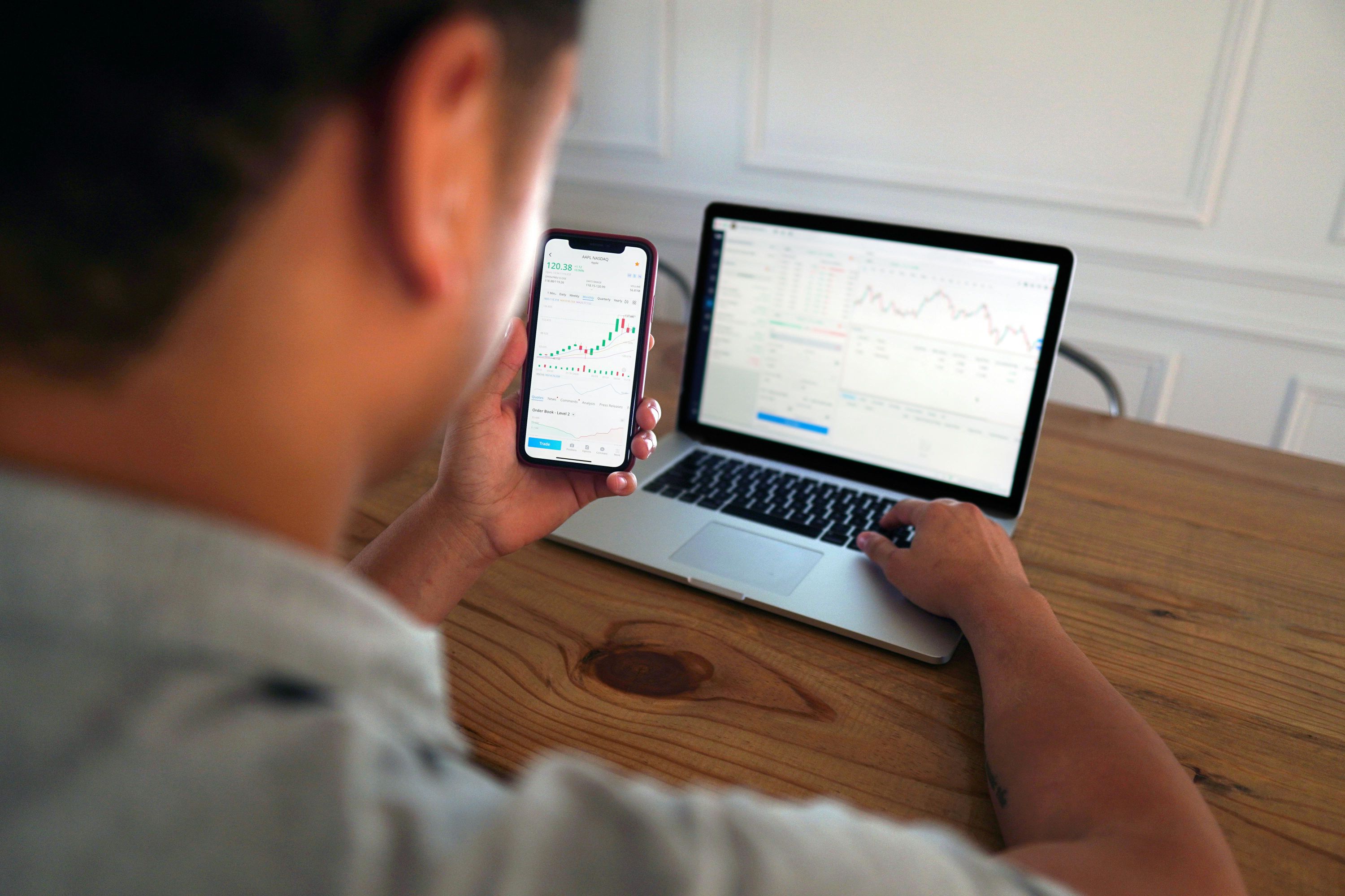 Person using a laptop and smartphone to review landing page performance data