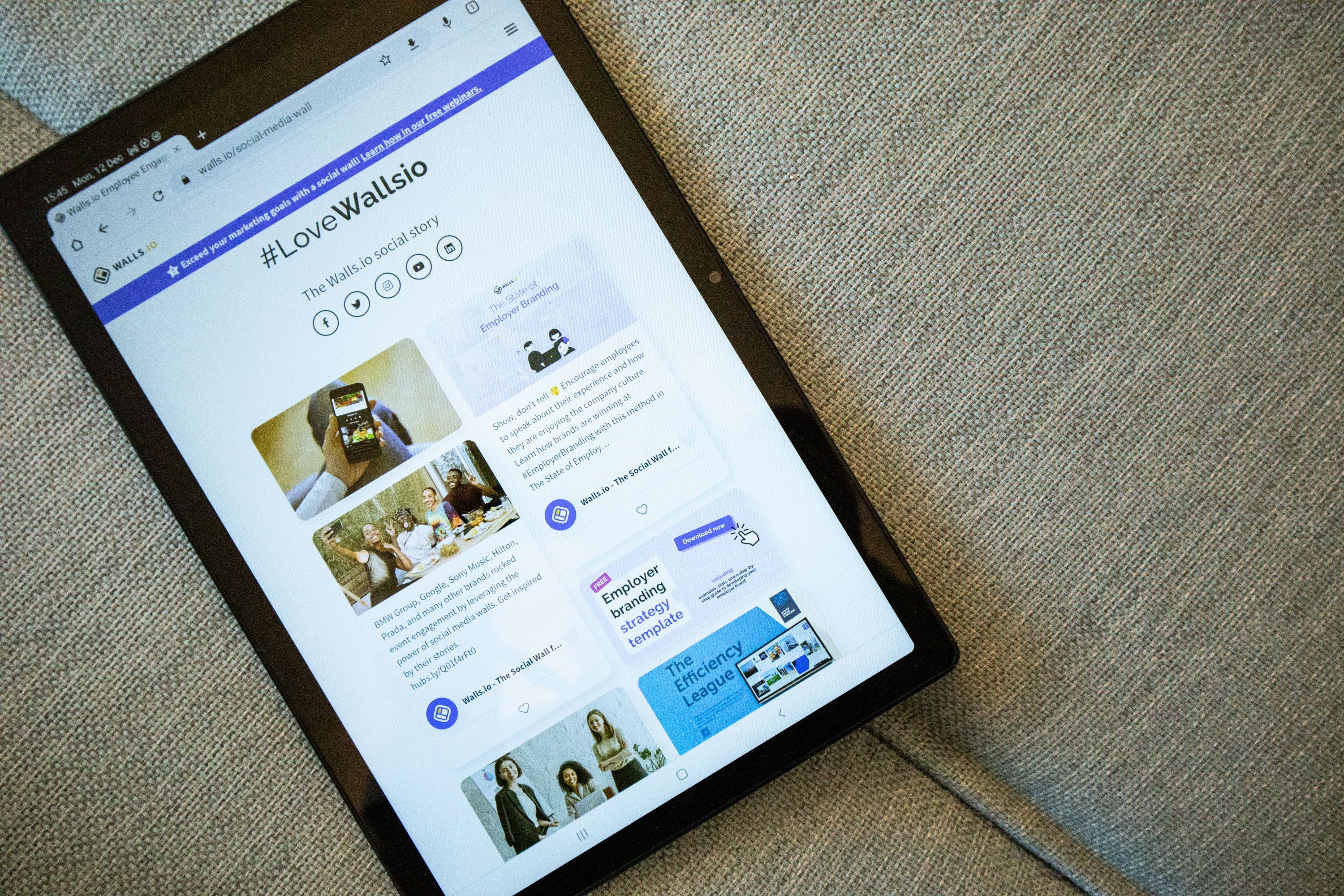 Tablet displaying a modern website interface on textured gray fabric